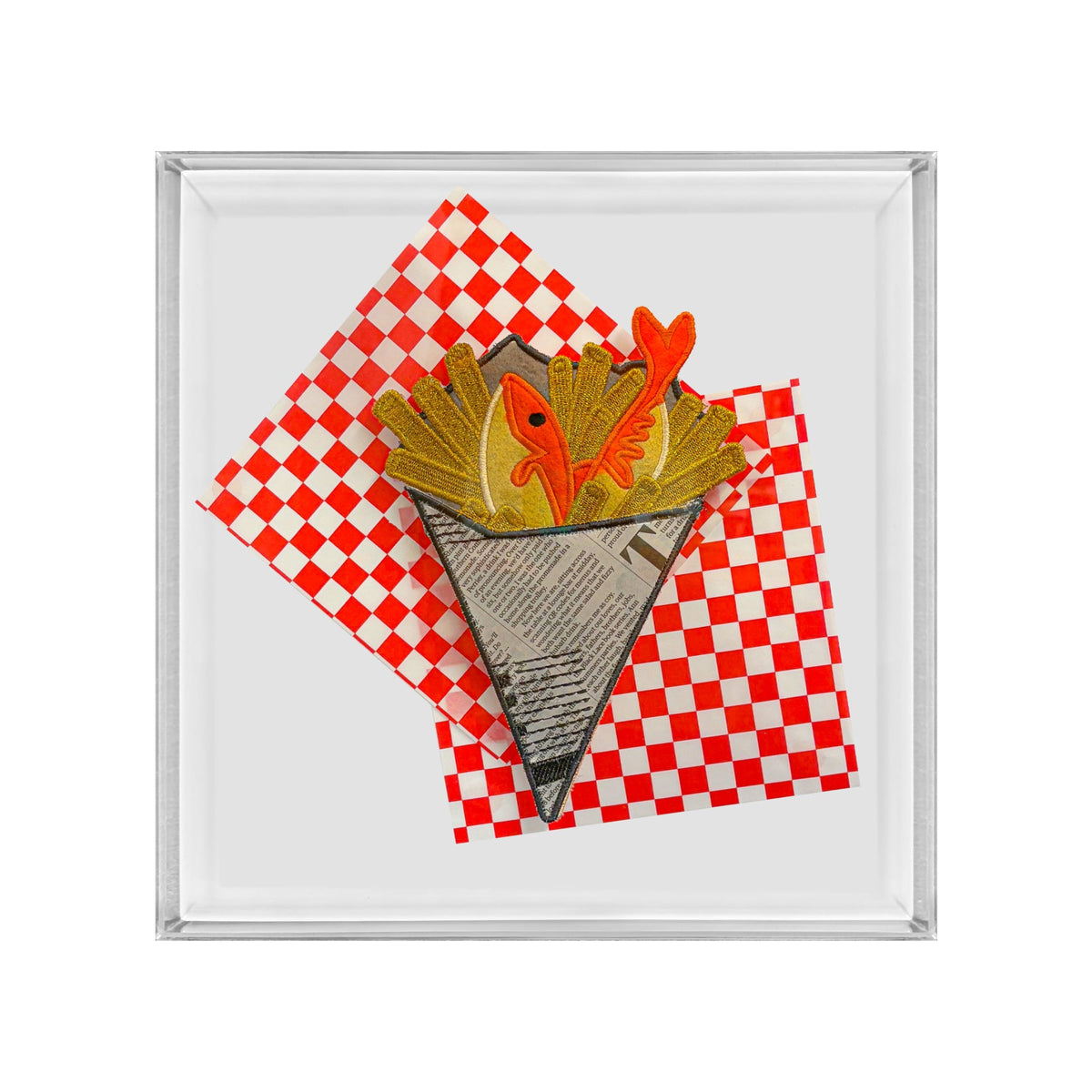 A square framed art print featuring a stylized illustration of french fries in a paper cone with two orange fish on top, set against a red and white checkered background.