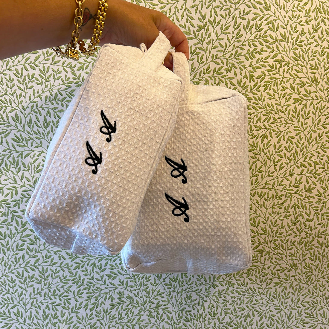 Small Lilly Loves monogramed black and white waffle makeup bag hanging, compact wash bag with elegant design.