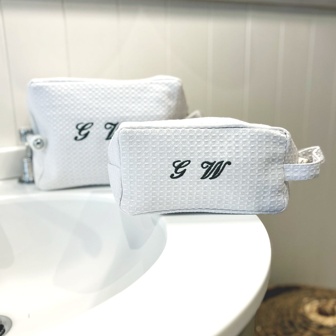 Small black and white monogrammed waffle makeup bag by Lilly Loves with green waffle fabric detail.